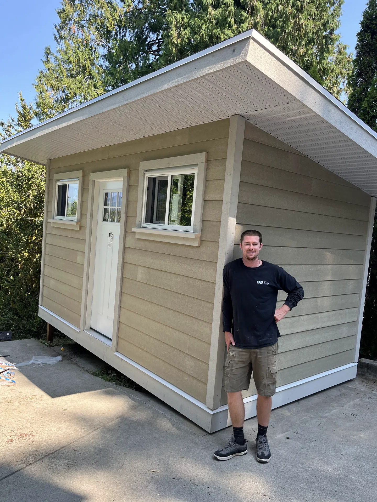 Sampson Higgins beside a backyard studio he built